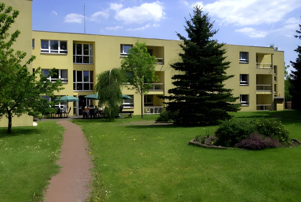 Altenpflegeheim mit gelber Fassade, Garten und Weg in Bad Münstereifel